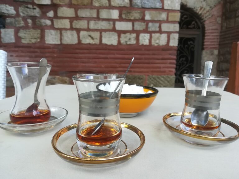 Drei fast leere Gläser mit türkischem Tee vor Zuckerschale auf Tisch