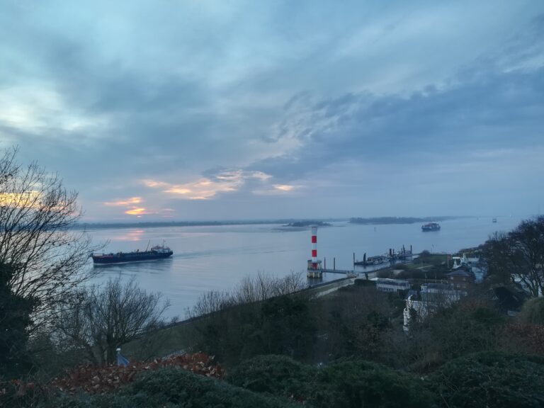 Blick auf die Elbe mit Schiffen, dramatische Wolken im Sonnenuntergang