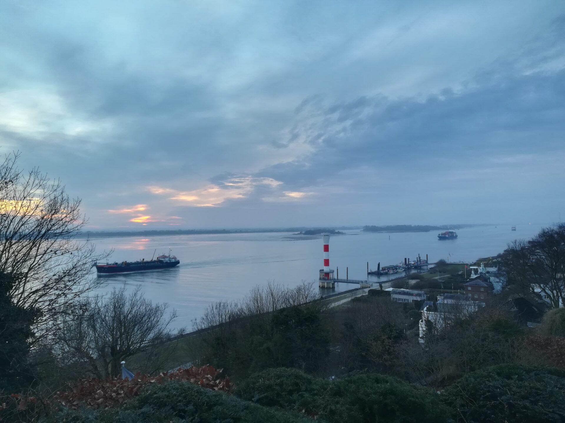 Blick auf die Elbe mit Schiffen, dramatische Wolken im Sonnenuntergang